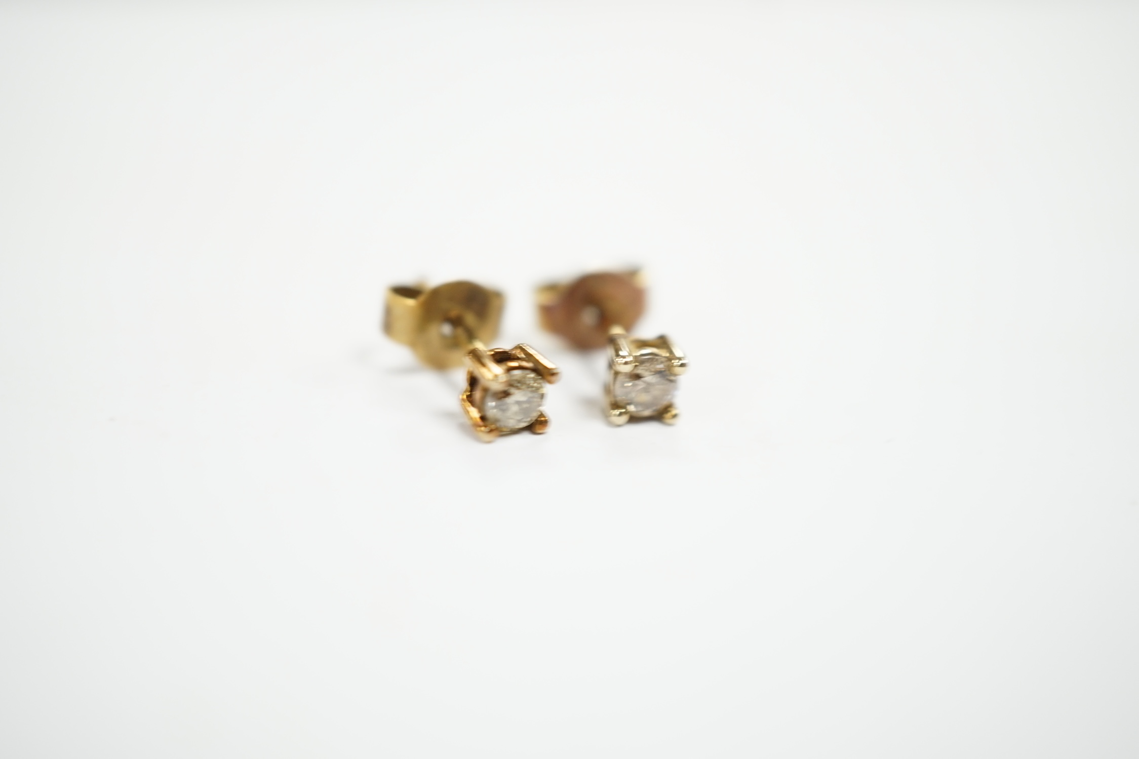 A small pair of 375 and solitaire diamond set ear studs, gross weight 0.8 grams.